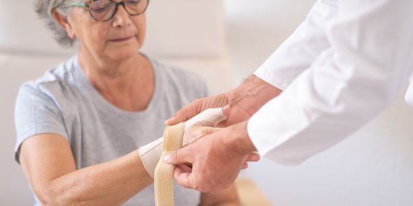 Soins d'une blessure au poignet chez une personne âgée.