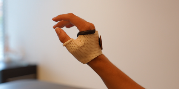 Main avec une orthèse blanche sur le doigt.