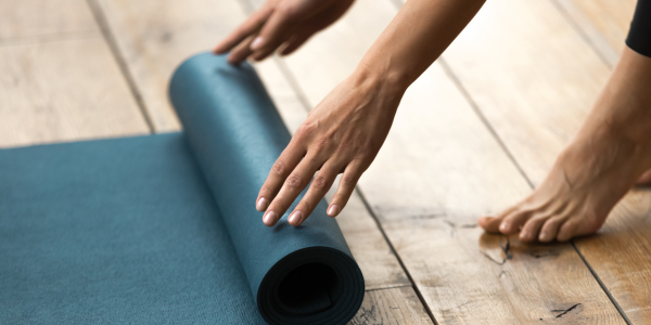 Personne enroulant un tapis de yoga