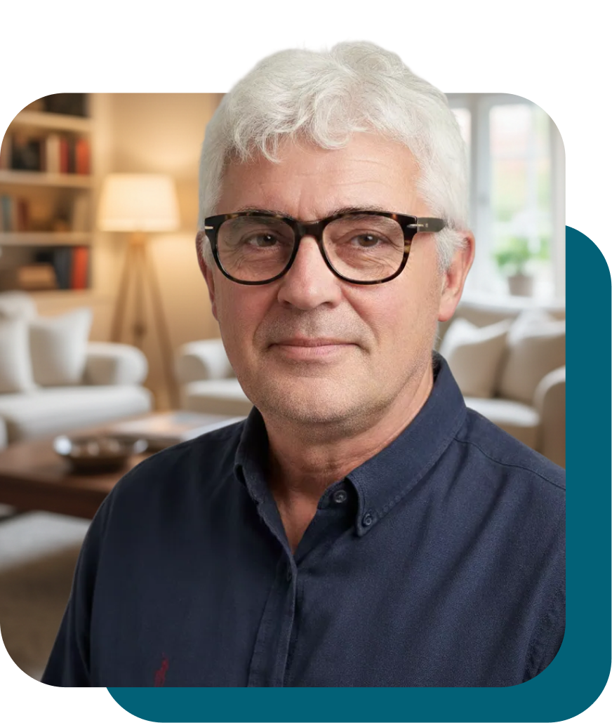 Man with glasses smiling in a living room.